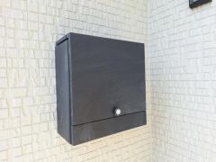 シンプルなデザインのポストが外観に溶け込み落ち着いた印象を与えます。ブラックカラーが壁の色と対比してスタイリッシュです。設置位置も使いやすそうです。防犯性にも配慮された形状となっています。