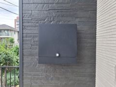 シンプルなデザインのポストが外壁に調和しています。落ち着いた色合いでスタイリッシュな印象を与えます。重厚感のある外壁が空間を引き締めています。