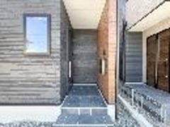 玄関はタイル敷きで清潔感があります。モダンな配色の外壁が印象的です。屋根が付いているため雨の日も安心して出入りできます。段差が低めで昇降もしやすい設計です。