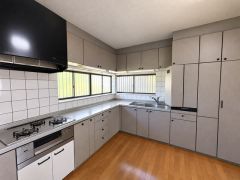 窓が多く明るい自然光が差し込むキッチンです。落ち着いた色合いが室内を引き締めています。