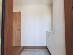 シンプルなデザインの収納スペースで玄関周りがすっきりと整います。扉付きの収納で中が見えにくく使い勝手が良い仕様です。明るい木目調が空間に馴染みやすい印象を与えます。モダンな印象の収納です。