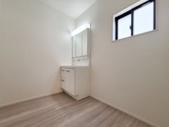 洗面台・洗面所はシンプルで使いやすいデザインが魅力です。明るい照明と清潔感のある空間が広がっています。収納スペースもすっきりとまとまっています。窓からの採光で自然な明るさが感じられます。