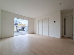 大きな窓から自然光が差し込むリビングです。床は明るい色合いで室内がより広く感じられます。