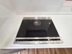 フラットなIHクッキングヒーターが設置されています。天板がすっきりとしておりお手入れも簡単です。キッチン全体がシンプルで清潔感のある印象です。