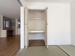 収納スペースには棚が設置されており小物から衣類まで整理しやすい仕様です。扉が大きく開くため内部のものを出し入れしやすい点も魅力です。室内の色調と統一された収納デザインがすっきりとした印象を与えます。
