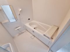 清潔感のあるバスルームです。シンプルな内装でお手入れがしやすい仕様となっています。ゆったりとした浴槽で床のスペースも広めです。ミラーや手すり付きで機能性に配慮されています。