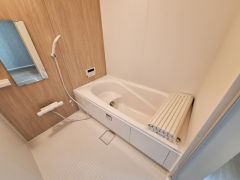 清潔感のあるバスルームは木目調のアクセントパネルがやさしい印象を与えます。独立したシャワーと使いやすい鏡も設置されています。浴槽には専用のフタがあり保温性も考えられています。