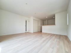 明るい色合いのフローリングが空間全体を広々と感じさせます。シンプルな内装でインテリアのアレンジがしやすいリビングです。対面キッチンがあり動線もすっきりしています。