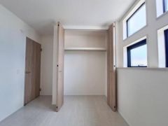 大きな扉付き収納が備え付けられており衣類や日用品の整理整頓がしやすいです。自然光が差し込む明るい室内も魅力の一つです。クローゼットは使いやすい形状で効率的な収納が可能です。