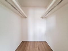 広々とした空間で収納力が魅力のクローゼットです。両側にハンガーパイプが設置されており衣類などを効率よく整理できます。シンプルな内装で使い勝手の良さが感じられます。