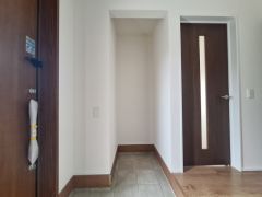 白を基調とした玄関はシンプルで清潔感があります。段差のある床が空間にメリハリを与えています。採光性のあるドアが明るさを演出しています。落ち着いた木目調のデザインで統一感があります。