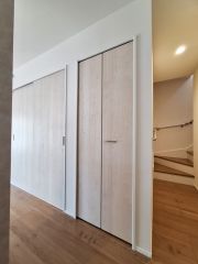 ナチュラルな色合いの建具が特徴のリビングです。階段への動線も確保され生活がしやすい設計となっています。収納スペースも十分に備わっており室内がすっきりとまとまります。