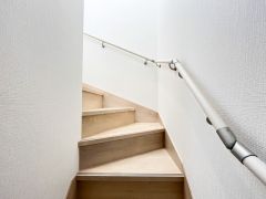 手すり付きで小さなお子様やご年配の方も安心な階段。明るい木目調が優しい雰囲気を演出します。