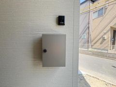 シンプルなデザインの宅配ボックスが設置されています。モダンな外観と調和しています。不在時でも荷物の受け取りが便利です。玄関まわりがすっきりとして見えます。扉のノブも使いやすい設計です。