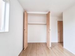 シンプルなデザインの収納スペースで室内がすっきりと見えます。両開き扉で使いやすく整理整頓がしやすい仕様です。明るい色合いの木目が空間全体に統一感を与えています。