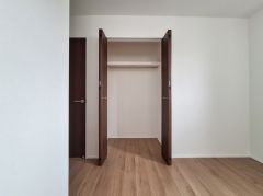 しっかりと奥行きのあるクローゼットです。シンプルなデザインで使い勝手も良好です。ドアの色味が室内の雰囲気を引き締め、空間をすっきりと見せてくれます。