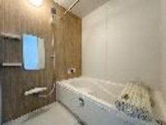 白を基調に、木目調の壁がやさしいアクセントになった浴室です。白のバスタブが空間にすっきりと馴染み、ナチュラルで落ち着いた雰囲気を感じられます。