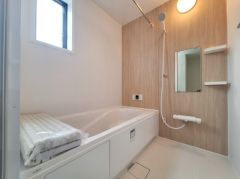 明るいカラーのパネルが使用され清潔感のあるバス空間です。窓が設置されており換気もしやすいです。浴槽とシャワースペースがしっかり確保されています。使いやすいシンプルな設計が特長です。