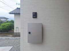 シンプルな外壁にポストとインターホンが設置されています。落ち着いた色合いで外観に調和しています。住宅の出入り口付近に設置されており使い勝手にも配慮されています。整然とした雰囲気が特徴です。
