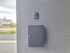 シンプルな外壁にスタイリッシュなポストとインターホンが設置されています。外観がすっきり整った印象を与えます。郵便物の受け取りにも便利な配置です。外壁のデザイン性が引き立っています。