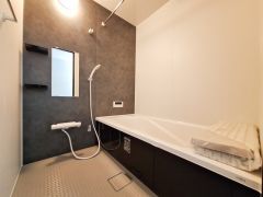 シックな黒のアクセントパネルが際立つ、モダンで洗練されたバスルーム。白と黒の美しいコントラストが、毎日のバスタイムを贅沢な癒やしの時間へと変えてくれます。
