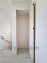 シンプルなデザインの収納スペースです。明るい色合いの内装が空間をすっきりと見せています。階段近くに位置しているので使い勝手にも配慮されています。扉付きで見た目も整っています。