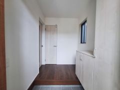玄関側に設けられた収納が空間をすっきり見せます。シンプルなデザインで無駄のない印象です。床の色合いと収納の扉が調和しています。収納スペースが充実しているので使い勝手も良好です。