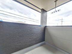 開放感のあるバルコニーで空が広く感じられます。壁面のカラーリングも落ち着いており空間がすっきりと見えます。屋根付きで雨の日も濡れにくい設計です。