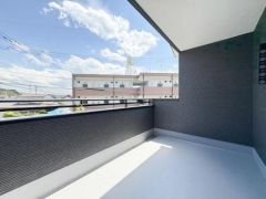バルコニーは屋根付きで急な天候の変化にも安心です。広々とした空間で開放感のある眺望を楽しめます。手すり部分はしっかりとした造りで落ち着いた色合いが特徴です。