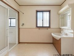 広々とした洗面所が魅力の空間です。窓付きで換気がしやすく、大きな鏡とゆとりある洗面台が設置されています。バスルームへの動線もスムーズです。