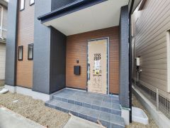 玄関周りは落ち着いた色合いで統一されており住まい全体に調和を感じます。広めのステップが設けられており段差の昇り降りも安心です。外観のアクセントとして木目調の壁面が使用されています。