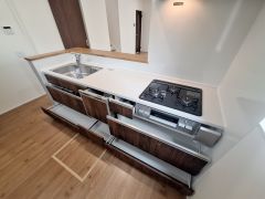 キッチンには広々としたカウンターとシンクが設けられ作業スペースが確保されています。収納力のある引き出しが並び整理整頓しやすい設計です。ガスコンロとシンクの配置も効率的で日々の作業をサポートします。