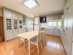 広々としたキッチンには収納が充実しており使いやすさが感じられます。 明るいフローリングと統一感のあるキャビネットが空間をすっきりと見せています。