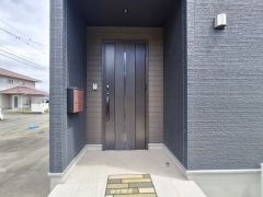 スタイリッシュな玄関ドアが印象的です。外壁と調和する落ち着いた色合いです。玄関まわりはゆとりあるスペースです。ポストが玄関横に設置され便利です。照明が設置されており夜間も安心です。
