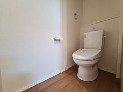 明るくシンプルなトイレ空間です。壁や床のカラーが清潔感を感じさせます。ペーパーホルダーなども設置され使いやすさが考慮されています。全体的にゆとりのあるつくりとなっています。
