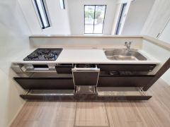 シンプルなデザインのキッチンです。直線的なレイアウトで作業スペースが広めに確保されています。収納が豊富で引き出しも使いやすく設計です。窓が多く明るさが感じられる空間です。