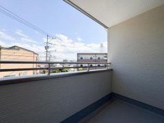 バルコニーは開放感があり広々としたスペースが確保されています。高めの手すりで安心感があります。空が広く見える見晴らしの良い設計です。屋根があるため雨の日も利用しやすいです。