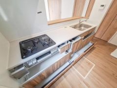 収納スペースが豊富に設けられているため整理整頓しやすいキッチンです。ガスコンロやシンクが使いやすい配置で設計されています。木目調の扉が温かみのある印象を与え手元の導線もスムーズです。