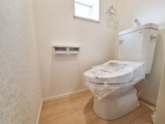 明るいトイレ空間で清潔感のある内装が特徴です。窓付きで換気も良好です。床の色合いが落ち着きを感じさせます。